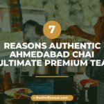 Steaming cup of authentic Ahmedabad chai with whole cardamom, nutmeg, and ginger spices on wooden ta